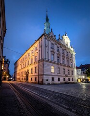 Obraz premium A large white building with a clock tower on a cobblestone street
