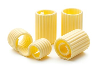 Freshly prepared dairy fat curls and cylindrical portions arranged against a bright white background