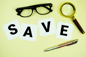 SAVE alphabet letters with magnifying glass, eye glasses and pen on yellow background © may1985