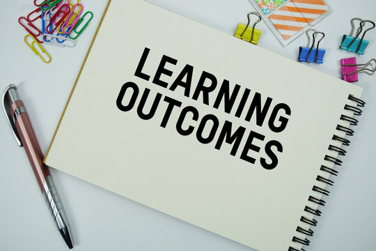 Learning Outcomes text message written on notepad with stationery flat lay on white background