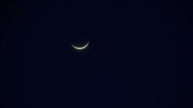冬の夜空を移動する三日月のタイムラプス風映像。下側が明るい冬の三日月。