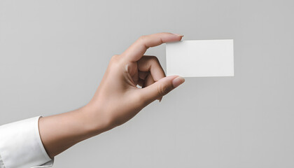 Fototapeta premium A Hand Holding A Blank Business Card Against A Plain Background