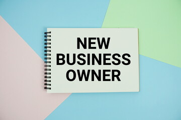 New Business Owner text written on notepad flat lay on multicolor pastel background
