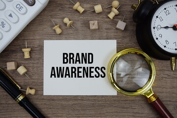Brand Awareness text written on notepad with pen, alarm clock, magnifying glass and calculator on...