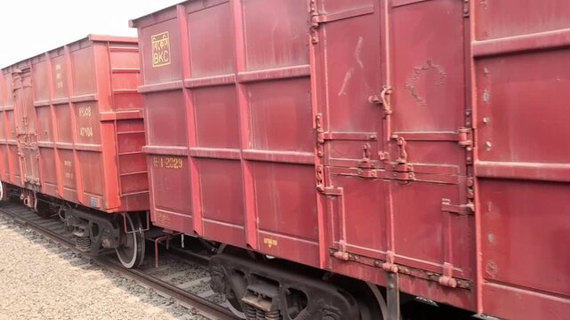 Close up view of a red Bangladesh railway train car and its wheel system on the railway track at a station
