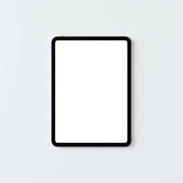 Modern black tablet device with blank white screen on a plain light gray background, top down view