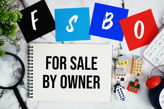 FSBO For Sale By Owner text written on notepad with house model, magnifying glass, calculator and alarm clock on marble background