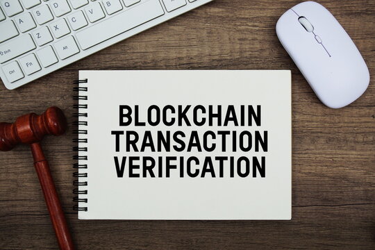 Blockchain Transaction Verification text written with gavel, keyboard and optical mouse on wooden background