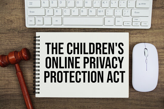 The Children's Online Privacy Protection Act text written on notepad with gavel and keyboard on wooden background