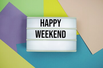 Happy Weekend text in lightbox flat lay on colorful pastel background