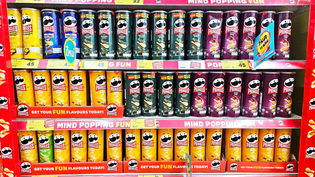 A vibrant display showcases rows of flavored Pringles potato chips, arranged meticulously on shelves with attractive packaging, offering a tempting treat for snack lovers. Thailand, February 25, 2026
