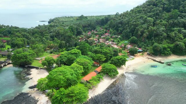 Aerial view of the small village on Ilheu das Rolas.It is an islet in the archipelago of S&atilde;o Tom&eacute; and Pr&iacute;ncipe, located in the Gulf of Guinea, south of the island. Africa Drone shot backwards