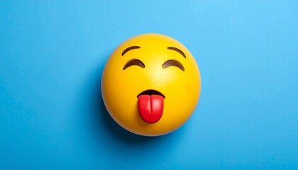 Naklejka premium Smiling emoji with tongue on blue background.