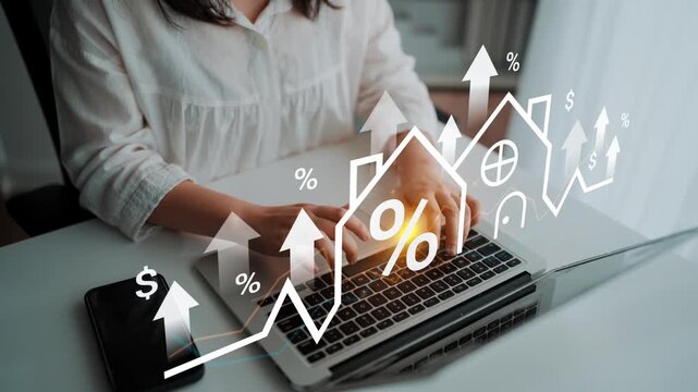 Business professional typing on laptop with graphs and symbols of growth in finance and real estate above a sleek workspace, emphasizing financial trends Gluon.