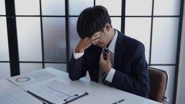 Stressed businessman holding head hard working in office