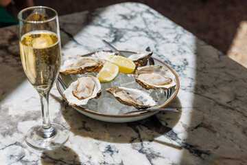 Fresh oysters on ice with champagne in sunlight
