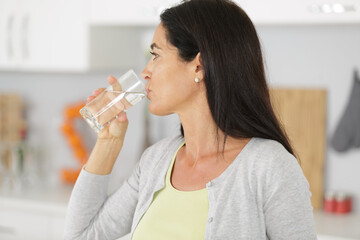 woman drinking water from glass isolated on grey