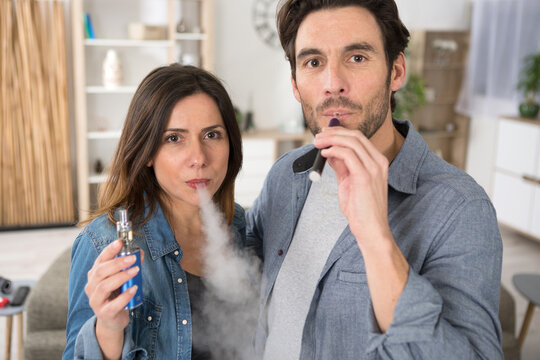 portrait of couple smoking electronic cigarettes