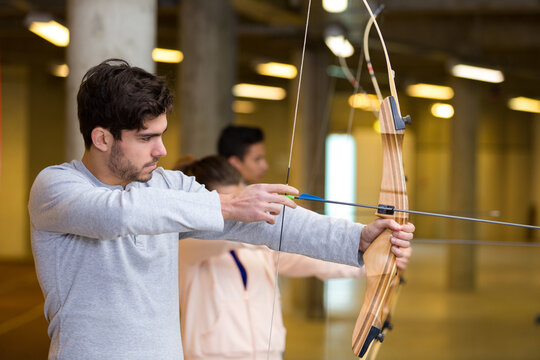 side view of young man practicing archery