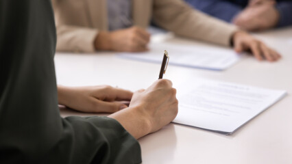 Close up image of woman signing contract during formal meeting in boardroom, buying company services, take loan or mortgage. Commitment of business parties concluding official deal at conference table © fizkes