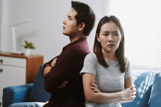 Angry couple turning their backs on each other at home, experiencing relationship problems and silent conflict