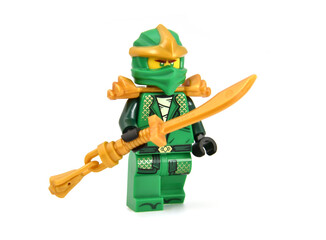 Fototapeta premium Editorial illustrative image of lego minifigure of green ninja Lloyd with golden blade or sword weapon isolated on white. Jubilee 15 years of lego Ninjago.