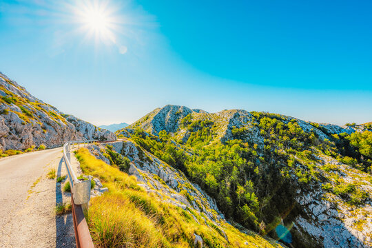 Rugged karst landscape of Biokovo Nature Park with white limestone rocks and sparse mediterranean vegetation, Dalmatia, Croatia.