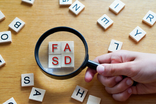 FASD, mental health and medicine concepts. Wooden letters with a magnifying glass on a wooden background
