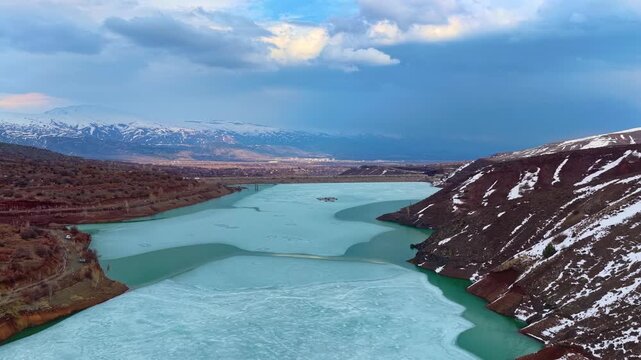 Cinematic Drone Shot of Frozen Lake and Mountain Valley Under Dramatic Sky