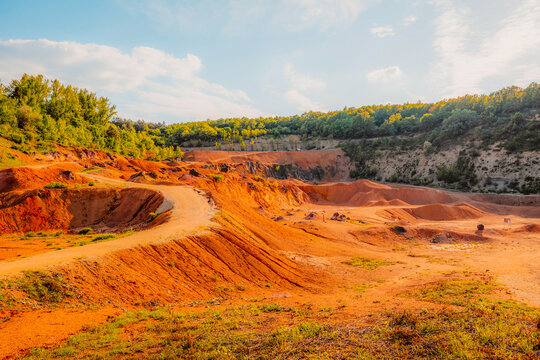 Gant, Hungary, view of the terraces of an old bauxite mine and bauxite formation with red and orange surface. G&aacute;nt Bauxitb&aacute;nya.