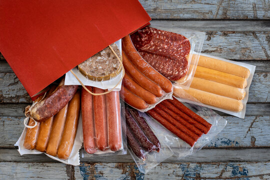 Vacuum sealed dried meats in the paper shopping bag.  Shopping from delicatessen concept. 