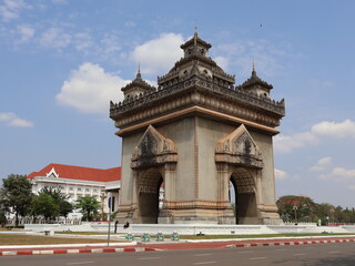VIENTIANE, LAOS - FEBRUARY 25, 2026: The iconic Patuxay Victory Gate monument under a blue sky with...