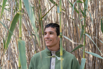 Smiling man observing nature in tall bamboo grove