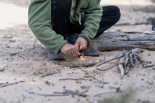 Person creating sparks for fire using flint steel