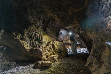 Woman exploring a deep dark underground cave