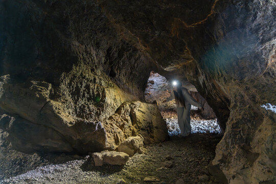 Woman exploring a deep dark underground cave