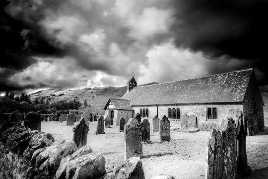 St Catherine church with fells and dramatic sky in background