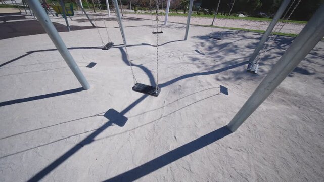 Row of Empty Swings in a Sunny Benidorm Park