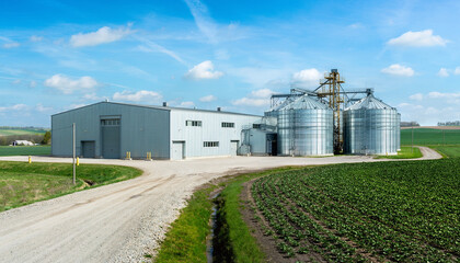 Modern farm building with grain silos and agricultural field