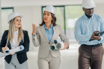 Architects team discussing building project with blueprints