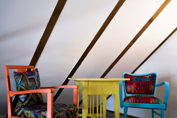 Two chairs and a small colorful table.