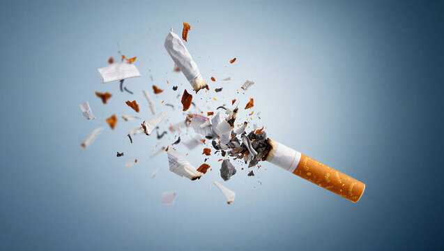 Exploding cigarette breaking apart with flying tobacco and ash on blue background, stop smoking and nicotine addiction concept.