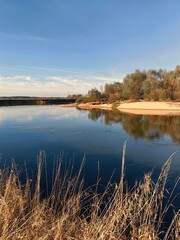 Fototapeta premium Landscape with river, blue sky, white sand beach.
