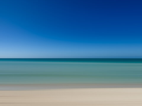 Abstract blurred view of turquoise ocean and sandy beach in Caribbean.
