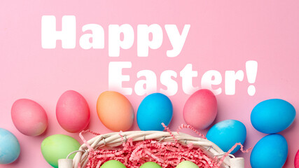 Fototapeta premium Colorful eggs in a basket with a festive greeting for Easter celebration in springtime