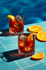 Red Negroni Cocktail Drink With Orange Garnish On Blue Table
