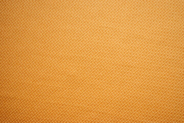 Fototapeta premium Primer plano de textura de tela de camisa en color mostaza con patrón de espiga.