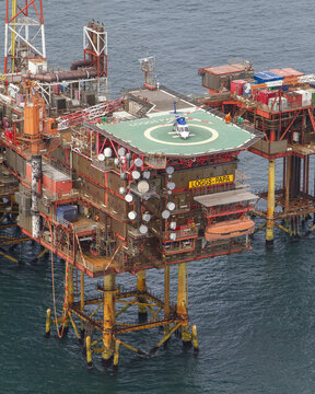 United Kingdom, United Kingdom - 15 February 2026: Aerial view of a colossal offshore oil platform with a helipad, standing firm against the deep blue sea, a testament to human engineering.