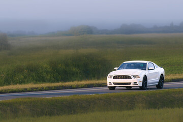 American muscle car driving on a scenic road