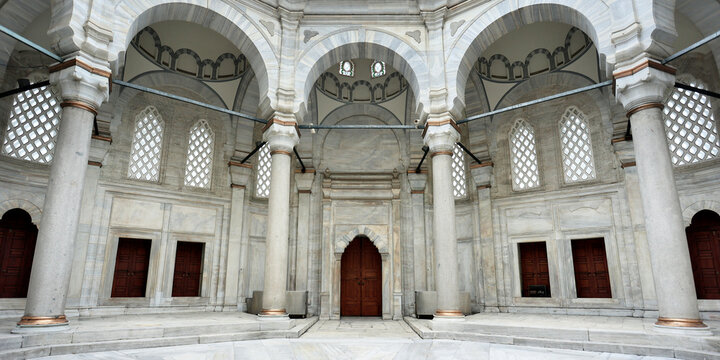 interior view of wooden door and white marble arches of muslim mosque in the city of Istanbul